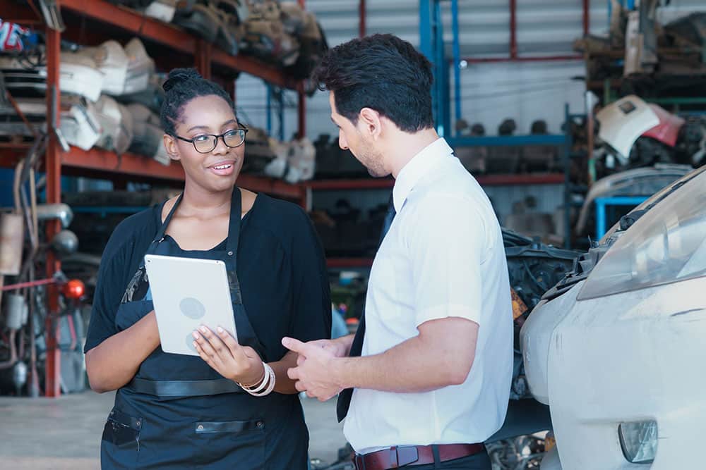 Business manager talking to worker inside factory-warehouse