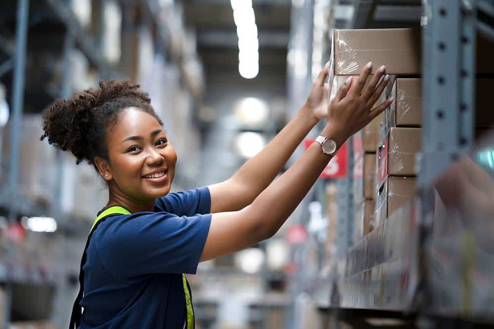 Warehouse worker take flat box from shelf in big warehouse factory